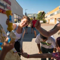 Vier Menschen unterschiedlichen Alters stehen vor einer Leinwand und tragen Senf auf.