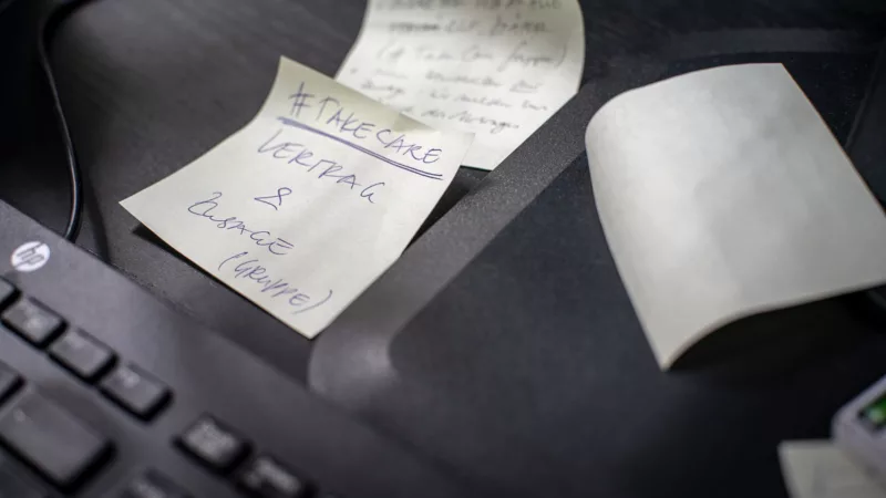 Post-it next to a keyboard on which "#TakeCare Contract & Commitment (groups)" can be read