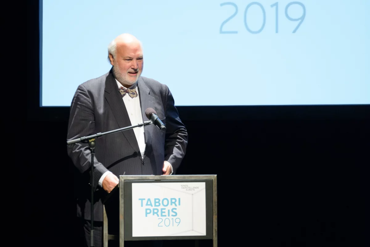 Prof. Dr. Wolfgang Schneider stands at the speaker's podium on the stage of the Tabori Award Ceremony 2019.