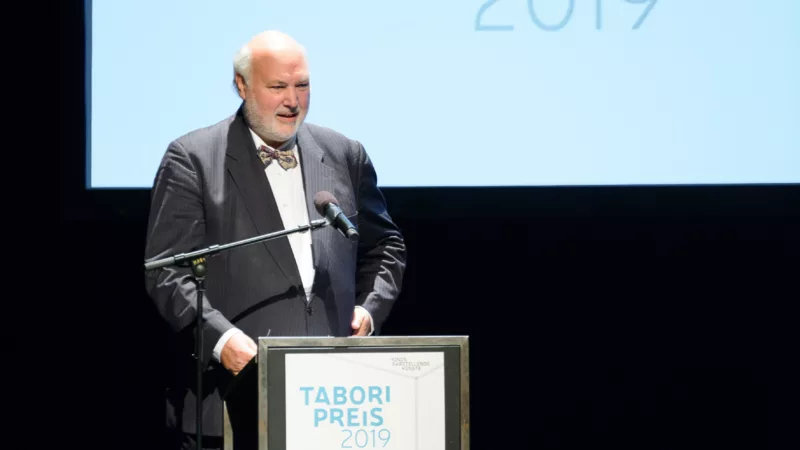 Prof. Dr. Wolfgang Schneider steht am Redner*innenpult auf der Bühne der Tabori Preisverleihung 2019.