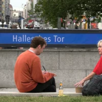 Ein Mann und eine Frau sitzen an der U-Bahnstation Hallesches Tor, um nach Protagonisten zu suchen.