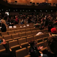 The picture shows the rows of seats in the hall of the Berliner Festspiele and people on the move.