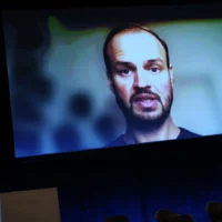 Jonas Zipf gives a keynote speech on the big screen via Zoom.