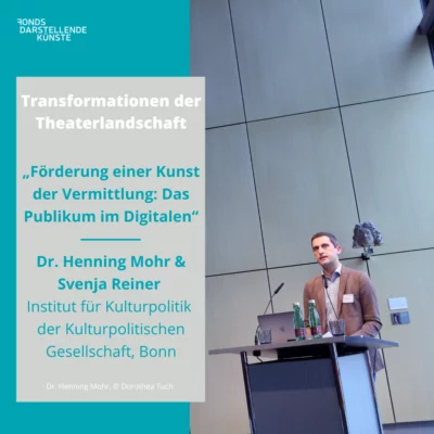 Portrait of Dr. Henning Mohr at the lectern. On the left edge of the picture is a text field with information about his lecture: "Transformations of the Theater Landscape - Promoting an Art of Mediation: The Audience in the Digital. - Dr. Henning Mohr & Sveja Reiner, Institute for Cultural Policy of the Cultural Policy Society, Bonn".