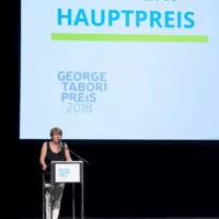 Amelie Deuflhard trägt ein Jury-Statement auf der Bühne des HAU 1 vor.