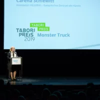 Carena Schlewitt bei der Verlesung ihres Jury-Statements für den Tabori Preis an die Gruppe Monster Truck auf der Bühne des HAU 1.