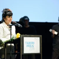 Sahar Rahimin during her acceptance speech for the Tabori Prize. Other members of the group can be seen in the background.