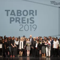 Gruppenbild mit Preisträger*innen und Programmbeteiligten beim Tabori Preis 2019 auf der Bühne im HAU1.
