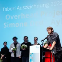 The ensemble of Overhead Project during their acceptance speech at the lectern.