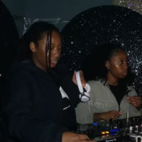 Two women at a DJ booth.
