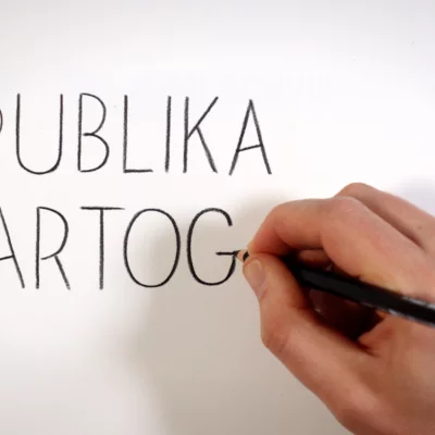 A hand can be seen writing Publika cartography in large letters on a sheet of paper.